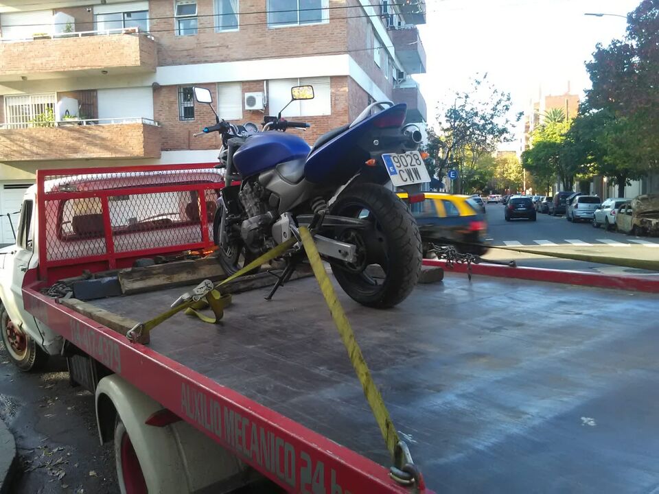 Remolque de moto con grúa de plataforma m-24 en Buenos Aires — auxilio mecánico 24 horas, teléfono 11 4417-4379 en el vehículo.